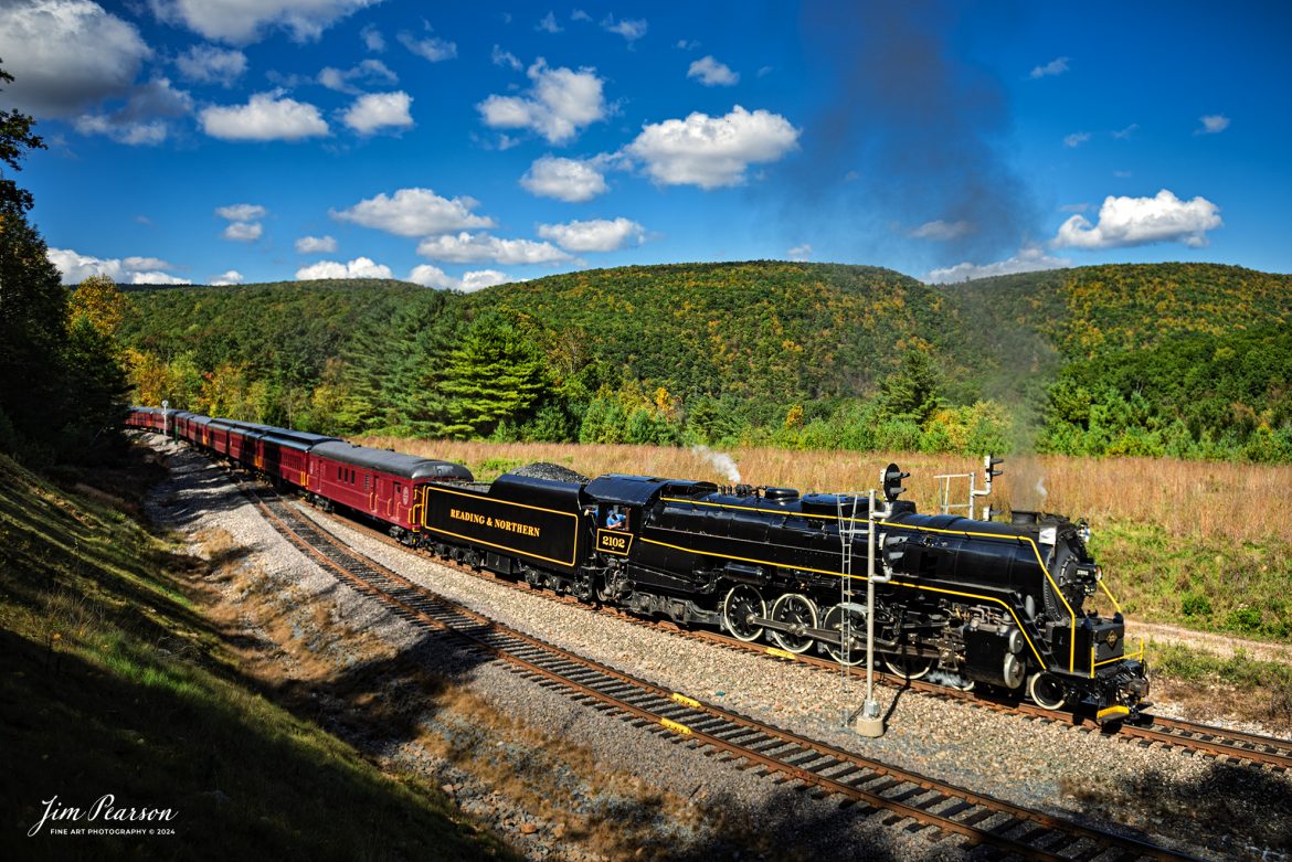 Reading & Northern's 2102 steam locomotive leads a passenger train as they turn their train on the wye just outside of Jim Thorpe, Pennsylvania, passing through Nesquehoning Tunnel on October 5th, 2024.

According to their website: The Reading Company T-1 class #2102 was built in the Reading’s own locomotive shops in 1945. With drivers of 70” diameter, it weighs 404 tons, and its tender holds up to 26 tons of coal, and up to 19,000 gallons of water. After the Reading Steam era was over, the Reading Company used 2102 for the Reading Rambles on several different excursions. The 2102 has had many different owners since it was retired by the Reading Railroad. It is one of only four to survive. The other remaining locomotives are the 2100, 2101, and 2124.

The Blue Mountain and Reading Railroad purchased the 2102 in 1987, and it ran on the Temple to South Hamburg line into the early 1990’s. Once the Blue Mountain and Reading Railroad became the Reading Blue Mountain & Northern, the 2102 ran over Reading & Northern’s rails for a short time before it was removed from service in the early 1990’s. 

In 2022, steam locomotive 2102 reentered service on the Reading & Northern. The locomotive has been used actively to pull both passenger excursions and revenue freight trains.

Tech Info: Nikon D810, RAW, Nikon 24-70 @ 24mm, f/2.8, 1/2000, ISO 100.

#steamtrains #besttrainphotograph #JimPearsonPhotography #RBNRR