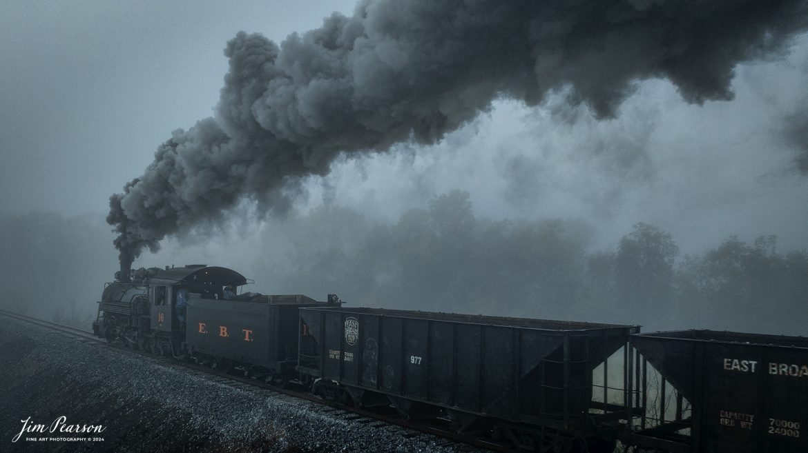 East Broad Top (EBT) steam locomotive #16 pulls a mixed freight through the early morning fog as they head to Rockhill Furnace, Pennsylvania on October 6th, 2024, during the museum’s Friends of the East Broad top event.

According to the East Broad Top Website: Locomotive #16 was built in 1916 by the Baldwin Locomotive Works.

Entering the age of modern steam in 1916, the EBT received its first of three large Mikados. Unlike the previous three smaller locomotives, #16 came with superheaters, piston valves, and Southern valve gear. One story mentions #16 pulled 60 empty hoppers from Mt. Union to Rockhill in one train, literally clearing out the yard. #16 underwent an overhaul in 1955 and made only a handful of trips in early 1956 before the railroad shut down an overhaul when the EBT shut down. On February 1, 2023, the locomotive returned to service.

Tech Info: DJI Mavic 3 Classic Drone, RAW, 24mm, f/2.8, 1/320, ISO 130.

#railroad #railroads #train, #trains #railway #railway #steamtrains #railtransport #railroadengines #picturesoftrains #picturesofrailways #besttrainphotograph #bestphoto #photographyoftrains #bestsoldpicture #JimPearsonPhotography #trainsfromtheair #trainsfromadrone #eastbroadtop