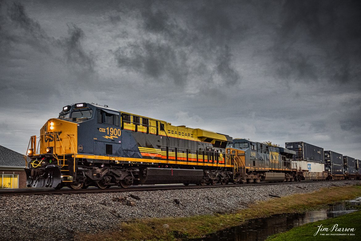 CSX I026 with CSX Seaboard Air Line Railroad Heritage Unit, 1900 leading, heads northbound in a light rain, at Crofton, Kentucky, on the CSX Henderson Subdivision, on November 13th, 2024, under stormy skies. 

According to a CSX Press Release: August 29, 2024 - CSX has unveiled its 18th heritage locomotive, a tribute to the Seaboard Air Line Railroad, marking another milestone in celebrating the rich history of American railroads. This latest addition to CSX's heritage series honors the legacy and the significant role that the Seaboard Air Line Railroad played in shaping the rail transport landscape in the United States.

The Seaboard Air Line Railroad, originally established in the late 19th century, was renowned for its efficient service and innovative routes, connecting the southeastern United States to the broader nation. Over the decades, it became famous for its passenger and freight services, symbolized by its slogan "Through the Heart of the South."

In 1967, Seaboard Air Line merged with the Atlantic Coast Line Railroad to form the Seaboard Coast Line Railroad. This merger was part of a larger trend in the railroad industry aimed at increasing efficiency and competitiveness. Eventually, Seaboard Coast Line became part of CSX Corporation in the 1980s through a series of mergers and consolidations that included the Chessie System and other lines. This ultimately positioned CSX as one of the leading rail networks in the U.S.

The creation of the Seaboard Air Line heritage unit was no small feat, showcasing the meticulous craftsmanship and dedication of ONE CSX team. Jeromy Hutchison, a CSX carman painter, commented on the complexity of the project, stating, "This was one of our harder projects. All of the stripes on the unit are hand laid, making it very complicated." The intricate detailing is a testament to the commitment delivering a great work product and honoring the legacy of the railroad. 

Tech Info: Nikon D810, RAW, Nikon 24-70 @ 24mm f/2.8, 1/400, ISO 2200.

#besttrainphotograph #bestphoto #photographyoftrains #bestsoldpicture #JimPearsonPhotography #csxheritagelocomotive #onecsx