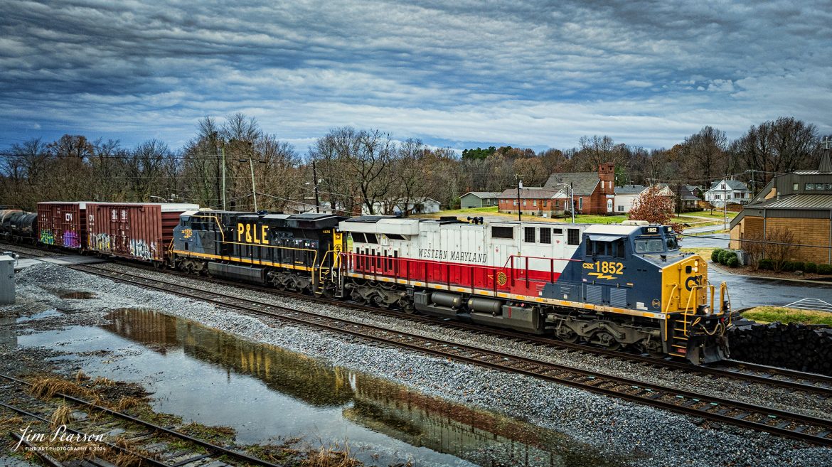 This is my first catch where there were two CSX Heritage Units leading a train! I got word about this move on CSX M648 the day before and when it finally arrived where I setup to catch it the first time at Mortons Gap, Ky the wind and rain was bad, but I did get a short video clip here is in my December 21st, 2024, Saturday Edited Video.

In this shot the Western Maryland and P&LE Heritage units lead M648 as it heads north through downtown Hanson, Kentucky on the CSX Henderson Subdivision on December 16th 2024.

According to the CSX Website: The Western Maryland Railroad operated between 1852 and 1983 in Maryland, West Virginia, and Pennsylvania. It was a small railroad that primarily transported coal and freight.

“In 1983 the Western Maryland fully merged with the B&O (Baltimore and Ohio Railroad), which merged with the C&O (Chesapeake and Ohio Railroad) in 1987. They eventually merged with the Seaboard System to form CSX.” explained Tim Music, a CSX carman painter who assisted with the project.

The Pittsburgh & Lake Erie Railroad was established in 1875 with a primary mission of transporting essential industrial materials such as coal, coke, iron ore, limestone, and steel among the bustling industrial hubs of the region.

“It’s mainline connected Pittsburgh, Pennsylvania with Youngstown, Ohio and Connellsville, Pennsylvania. It did not actually reach Lake Erie until 1976,” explained Tim Music, a carman painter at the CSX Waycross Locomotive Shop where the unit was produced.

Despite its relatively modest route mileage, the P&LE Railroad earned the nickname “Little Giant” due to the enormous volume of heavy tonnage it moved. This impressive capability drew significant attention and by 1887, the P&LE became a subsidiary of the dominant New York Central Railroad. Under this new ownership, the P&LE enjoyed substantial improvements to its tracks and added capacity for passenger services, further enhancing its regional significance.

Tech Info: DJI Mavic 3 Classic Drone, RAW, 24mm, f/2.8, 1/640, ISO 170.

#railroad #railroads #train, #trains #railway #railway #railtransport #railroadengines #picturesoftrains #picturesofrailways #besttrainphotograph #bestphoto #photographyoftrains #bestsoldpicture #JimPearsonPhotography #trainsfromadrone #csxheritagelocomotives