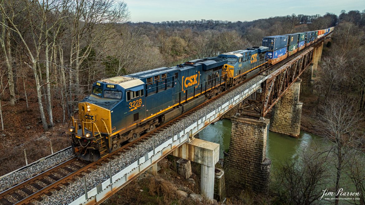 CSXT 3228 leads hot intermodal I026 as they head north over the Red River bridge on the CSX Henderson Subdivision at Adams, TN, on January 9th, 2025. 

Tech Info: DJI Mavic Classic 3 Drone, RAW, 4.5mm (24mm equivalent lens) f/2.8, 1/500, ISO 170.

#railroad #railroads #train #trains #bestphoto #railroadengines #picturesoftrains #picturesofrailway #bestphotograph #photographyoftrains #trainphotography #JimPearsonPhotography