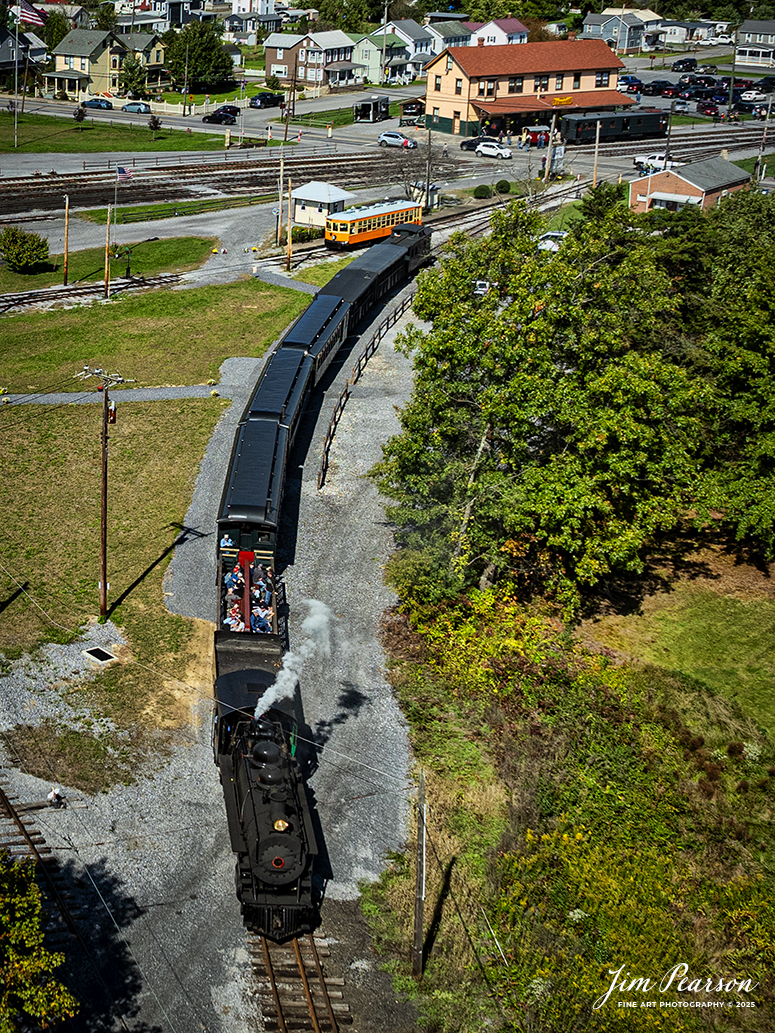 East Broad Top (EBT) steam locomotive #16 pulls a passenger train past the depot as they enter the yard on the wye at Rockhill Furnace, Pennsylvania to turn their train for another trip, on October 6th, 2024, on a beautiful fall afternoon.

According to the East Broad Top Website: Locomotive #16 was built in 1916 by the Baldwin Locomotive Works.

Entering the age of modern steam in 1916, the EBT received its first of three large Mikados. Unlike the previous three smaller locomotives, #16 came with superheaters, piston valves, and Southern valve gear. One story mentions #16 pulled 60 empty hoppers from Mt. Union to Rockhill in one train, literally clearing out the yard. #16 underwent an overhaul in 1955 and made only a handful of trips in early 1956 before the railroad shut down an overhaul when the EBT shut down. On February 1, 2023, the locomotive returned to service.

Tech Info: DJI Mavic 3 Classic Drone, RAW, 24mm, f/2.8, 1/1600, ISO 100.

#steamtrains #JimPearsonPhotography #trainsfromtheair #EastBroadTop