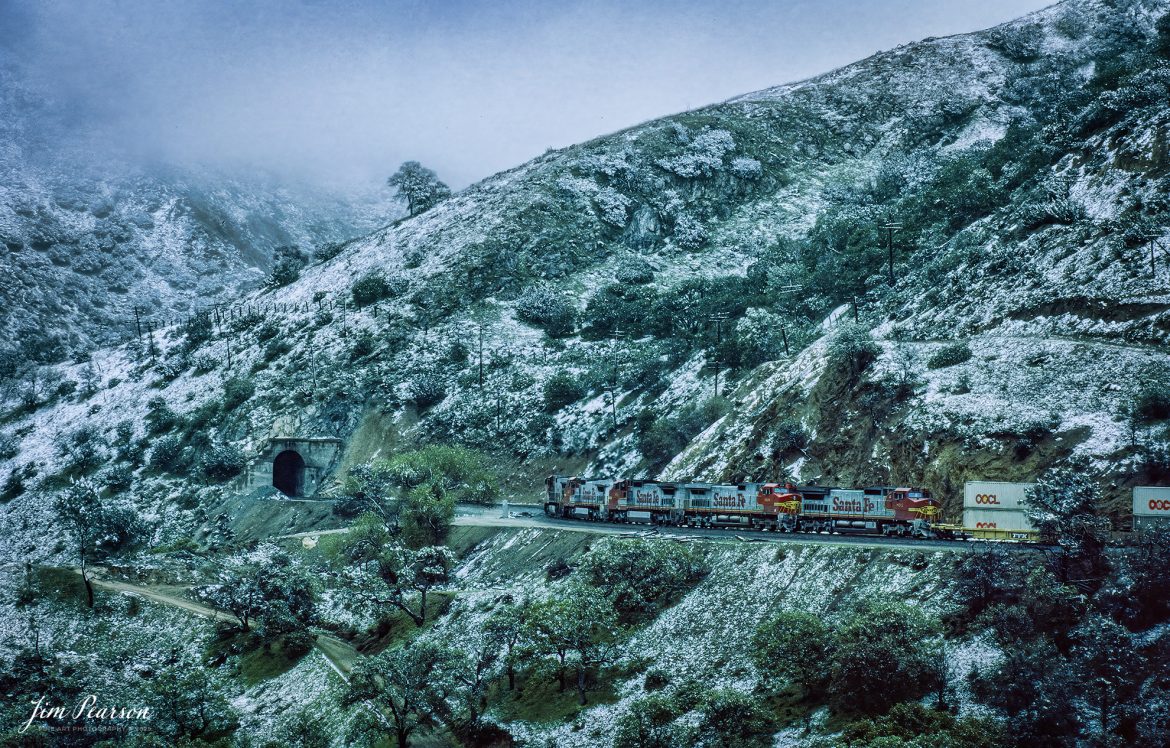 Film Wednesday – Five Santa Fe Warbonnet units lead a loaded intermodal as it approaches one of the many tunnels in the Tehachapi mountains of California that was shot sometime in the mid 1990’s. 

According to Wikipedia: The Atchison, Topeka and Santa Fe Railway (reporting mark ATSF), often referred to as the Santa Fe or AT&SF, was one of the largest Class 1 railroads in the United States between 1859 and 1996.

The Santa Fe was a pioneer in intermodal freight transport; at various times, it operated an airline, the short-lived Santa Fe Skyway, and the Santa Fe Railroad tugboats.[2] Its bus line extended passenger transportation to areas not accessible by rail, and ferryboats on the San Francisco Bay allowed travelers to complete their westward journeys to the Pacific Ocean. The AT&SF was the subject of a popular song, Harry Warren and Johnny Mercer's "On the Atchison, Topeka and the Santa Fe", written for the film The Harvey Girls (1946).

The railroad officially ceased independent operations on December 31, 1996, when it merged with the Burlington Northern Railroad to form the Burlington Northern and Santa Fe Railway.

Tech Info: Camera, Nikon F3, Kodachrome Slide Film, no other data recorded

#slidescan #filmphotography #trains #railroads #jimpearsonphotography