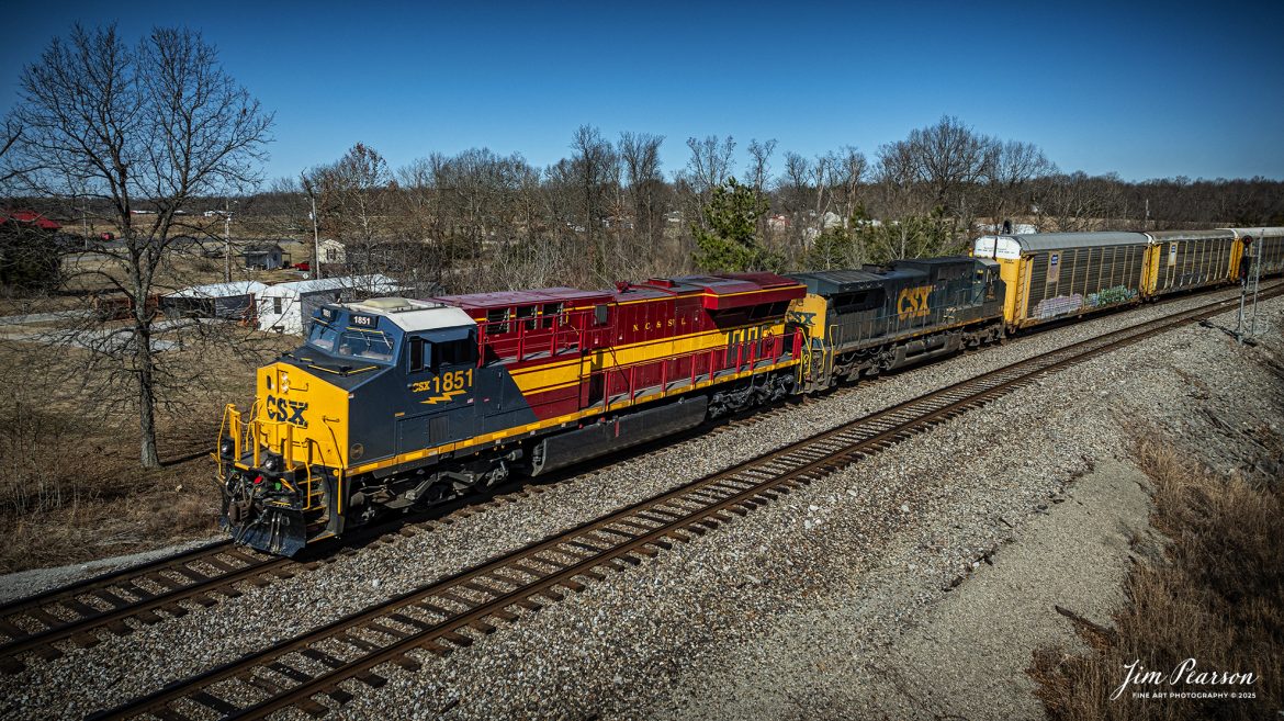 CSX I025 with CSX NC&SL Heritage Unit 1851 leading, heads south past the north end of the siding at Kelly, Kentucky on the CSX Henderson Subdivision, on January 27th, 2025. This train typically runs with autoracks behind the power which contain Tesla's bound for Florida.

According to a CSX Press Release: September 20, 2024 - Railroads have long played a crucial role in shaping the economic and cultural landscapes of the United States. Among these storied lines is the Nashville, Chattanooga, and St. Louis (NC&StL) Railway, a key player in the growth of the Southeast. CSX has unveiled its 19th heritage locomotive, a tribute to the NC&StL Railway, celebrating the rich legacy of a system integral to regional development.

Operating from 1851 to 1957, the NC&StL Railway was a vital freight and passenger route, connecting communities across Tennessee and other Southern states. It facilitated the movement of goods and people, boosting commerce and fostering community development along its routes. The railway's strategic links between Nashville, Chattanooga, and St. Louis significantly contributed to the urban and industrial growth of these cities, supporting industries such as agriculture, coal, and manufacturing.

To honor the historical significance of the NC&StL Railway, CSX introduced the Nashville, Chattanooga, and St. Louis heritage locomotive. This initiative is part of CSX’s broader program to preserve the legacy of railroads that are now part of its extensive network. Each heritage unit is carefully crafted to pay homage to the unique identity and history of its predecessor, featuring colors and designs reminiscent of the original rail lines. 

Tech Info: DJI Mavic 3 Classic Drone, RAW, 22mm, f/2.8, 1/2000, ISO 100.

#besttrainphotograph #bestphoto #photographyoftrains #bestsoldpicture #JimPearsonPhotography #csxheritagelocomotive #onecsx