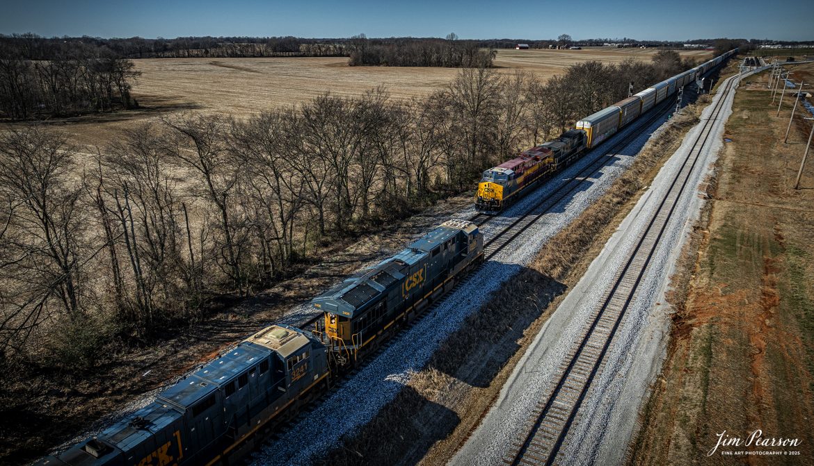 CSX I025 with CSX NC&SL Heritage Unit 1851 leading, heads south as they meet their counterpart, I026, at Moore, just north of Guthrie, Kentucky on the CSX Henderson Subdivision, on January 27th, 2025. 

The track to the right is the new spur that will service the new Novelis plant being built at Guthrie. 

According to a CSX Press Release: September 20, 2024 - Railroads have long played a crucial role in shaping the economic and cultural landscapes of the United States. Among these storied lines is the Nashville, Chattanooga, and St. Louis (NC&StL) Railway, a key player in the growth of the Southeast. CSX has unveiled its 19th heritage locomotive, a tribute to the NC&StL Railway, celebrating the rich legacy of a system integral to regional development.

Operating from 1851 to 1957, the NC&StL Railway was a vital freight and passenger route, connecting communities across Tennessee and other Southern states. It facilitated the movement of goods and people, boosting commerce and fostering community development along its routes. The railway's strategic links between Nashville, Chattanooga, and St. Louis significantly contributed to the urban and industrial growth of these cities, supporting industries such as agriculture, coal, and manufacturing.

Tech Info: DJI Mavic 3 Classic Drone, RAW, 22mm, f/2.8, 1/2000, ISO 130.

#besttrainphotograph #bestphoto #photographyoftrains #bestsoldpicture #JimPearsonPhotography #csxheritagelocomotive #onecsx