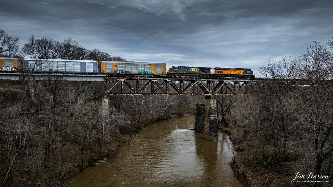 CSXT 1973, Chessie System Heritage Unit, leads CSX I025 as it passes over the Red River Trestle just north of Adams, TN as it heads south on the CSX Henderson Subdivision, on February 14th, 2025. 

According to Wikipedia: The three railroads that would make up the Chessie System had been closely related since the 1960s. C&O had acquired controlling interest in B&O in 1962, and the two had jointly controlled WM since 1967.

Chessie System, Inc. was a holding company that owned the Chesapeake and Ohio Railway (C&O), the Baltimore and Ohio Railroad (B&O), the Western Maryland Railway (WM), and Baltimore and Ohio Chicago Terminal Railroad (B&OCT). Trains operated under the Chessie name from 1973 to 1987.

On November 1, 1980, Chessie System merged with Seaboard Coastline Industries to form CSX Corporation. Initially, the three Chessie System railroads continued to operate separately, even after Seaboard’s six Family Lines System railroads were merged into the Seaboard System Railroad on December 29, 1982. That began to change in 1983, when the WM was merged into the B&O. The Chessie image continued to be applied to new and re-painted equipment until July 1, 1986, when CSXT introduced its own paint scheme. In April 1987, the B&O was merged into the C&O. In August 1987, C&O merged into CSX Transportation, a 1986 renaming of the Seaboard System Railroad, and the Chessie System name was retired.

Tech Info: DJI Mavic 3 Classic Drone, RAW, 22mm, f/2.8, 1/1250, ISO 140.

#railroad #railroads #train, #trains #railway #railway #railtransport #railroadengines #picturesoftrains #picturesofrailways #besttrainphotograph #bestphoto #onecsx #photographyoftrains #bestsoldpicture #JimPearsonPhotography #trainsfromadrone #csxheritageunit