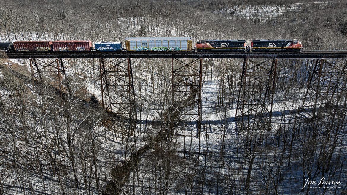 Rerouted Canadian National 2256 and 2225 lead southbound CSX X770-20 as it crosses over Gum Lick Trestle, between Crofton and Kelly, Kentucky, on the CSX Henderson Subdivision, on February 20th, 2025.

I’m told this is the first of many CN Reroutes off the CN due to flood damage around Cairo Sub at Bardwell, Ky. These are running from CN to Paducah, where they get on the Paducah and Louisville Railway to the CSX Henderson Subdivision at Madisonville, Ky. From there they run to Nashville and then over to Memphis, TN

Tech Info: DJI Mavic 3 Classic Drone, RAW, 22mm, f/2.8, 1/2000, ISO 120.

#railroad #railroads #train, #trains #railway #railway #railtransport #railroadengines #picturesoftrains #picturesofrailways #besttrainphotograph #bestphoto #photographyoftrains #bestsoldpicture #JimPearsonPhotography #trainsfromadrone #canadiannational #cnrailway