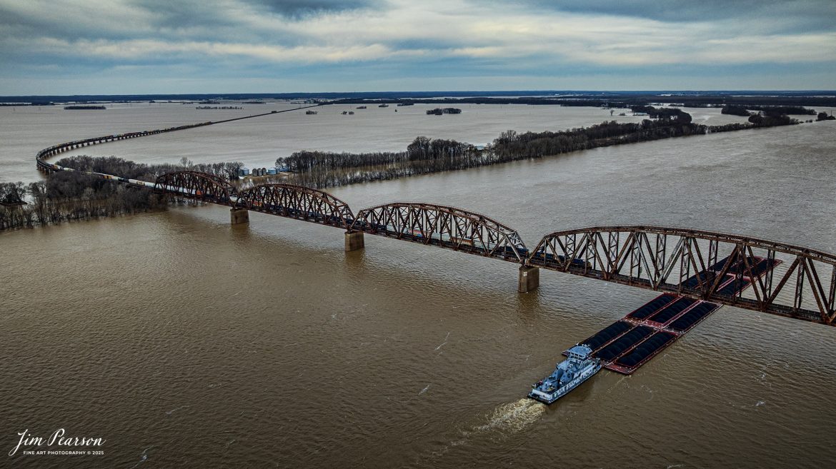 Talk about f/8 and being there!! In all my years railfanning at this spot I’ve always wanted to catch a barge and train here at the Ohio River crossing at Henderson, Kentucky and yesterday, February 24th, 2025!  

I tried to get to Rahm, IN which is across the river, but as you can see the Ohio River has overflowed its banks into the floodplain, so it was not possible to drive back there. Instead, I went to the Henderson side as I knew that M647 was going to be heading south from Evansville, Indiana. 

I knew I could fly from the boat ramp at Henderson, Ky, when it crossed the river and capture this shot showing all the flooding as it headed south on the CSX Henderson Subdivision. 

Tech Info: DJI Mavic 3 Classic Drone, RAW, 22mm, f/2.8, 1/1250, ISO 100.

#railroad #railroads #train, #trains #railway #railway #railtransport #railroadengines #picturesoftrains #picturesofrailways #besttrainphotograph #bestphoto #photographyoftrains #bestsoldpicture #JimPearsonPhotography #trainsfromadrone #flooding #csxhendersonsubdivision #onecsx