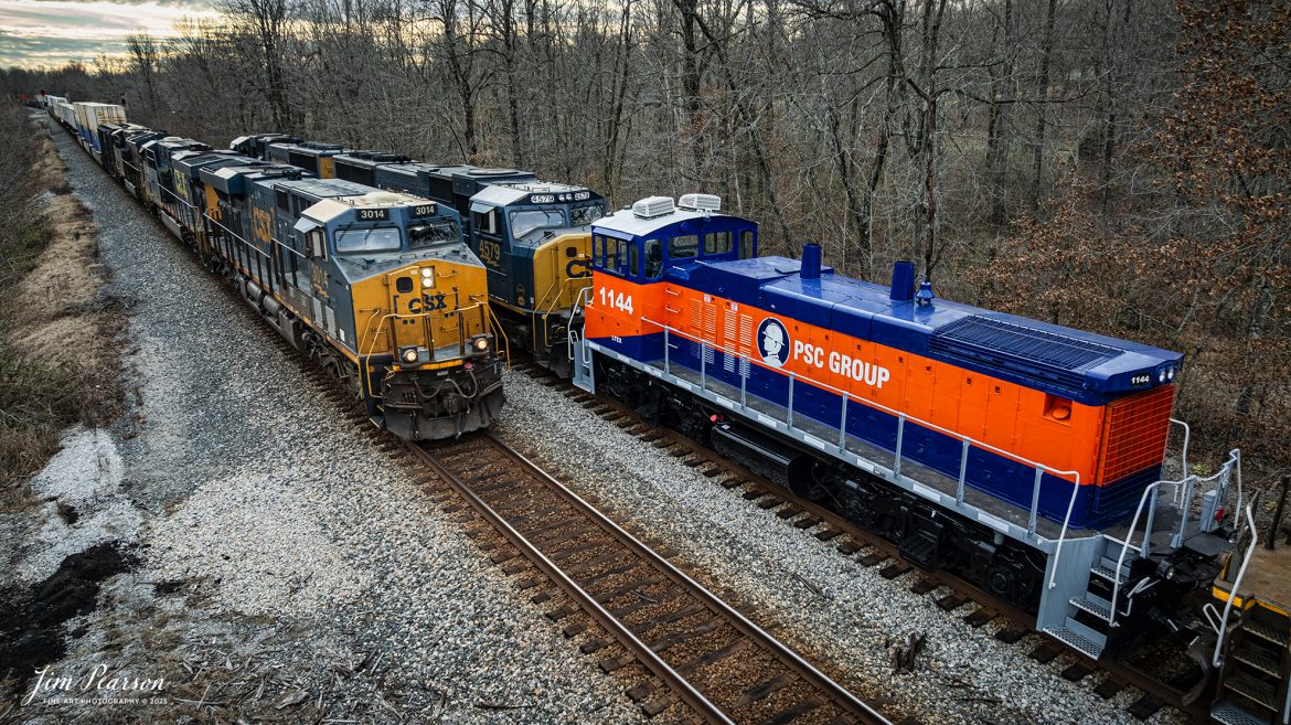 Southbound CSX M513 waits at Romney, south of Nortonville, Kentucky as CSX northbound Intermodal I128 passes them on track 2, on January 17th, 2025, on the Henderson Subdivision.

M513 has PCS Group Switcher 1144 as the third unit and an ex-Union Pacific 4669 with reporting marks of SPTX stenciled on the side of the cab, with both units dead in tow.

According to their website, “PSC Group provides turnkey solutions for safe and efficient rail switching in some of the most challenging and complex sites throughout North America. We manage more than 75 rail switching sites using our own fleet of advanced locomotives and mobile railcar movers, proven safety methods, and highly skilled personnel. By working closely with our customers, we tailor our services to their unique needs, utilizing over 80 locomotives, 30 mobile railcar movers (Trackmobiles and Shuttle Wagons), and more than 1,000 skilled employees to enhance safety, decrease cycle time, prevent derailments, and optimize railcar utilization.

Over the years, we have found that performing railcar switching alongside loading/unloading, railcar repair, and inspections, creates a safer and more efficient operating environment while simultaneously delivering considerable savings. By bundling these synergistic services together, we can provide the most value to our customers' operations.”

Tech Info: DJI Mavic 3 Classic Drone, RAW, 24mm, f/2.8, 1/640, ISO 320.

#bestphoto #trains #bestsoldpicture #JimPearsonPhotography #trainsfromtheair #trainsfromadrone