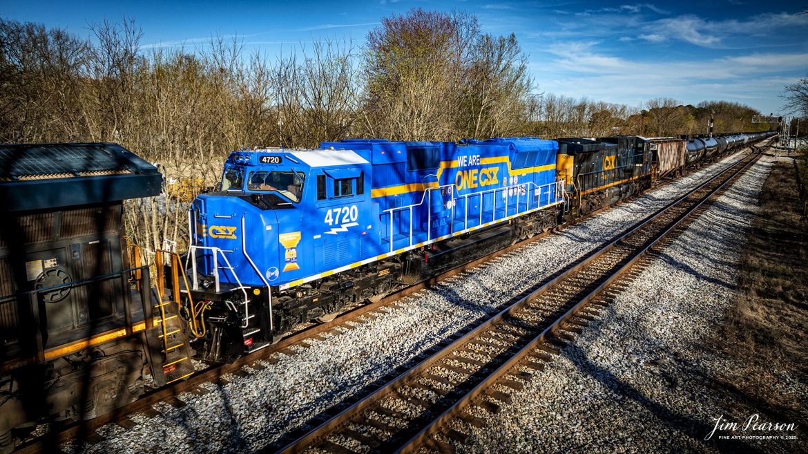 CSX E040 waits at Guthrie, Ky with ethanol train (B622) and the We Are One CSX locomotive 4720 as a mid-train DPU at Guthrie, Kentucky on March 18th, 2025, on the CSX Henderson Subdivision. This is my first time catching this locomotive out in the wild and while I wish it had been leading but I’ll take what I can get!  I totally love the look of this locomotive!

According to a CSX press release, January 14, 2025 - CSX has introduced the ONE CSX locomotive, a specially designed engine to symbolize the company’s commitment to fostering collaboration, inclusion, and mutual respect across its workforce.

“This locomotive celebrates our ONE CSX team and culture,” said CSX President and Chief Executive Officer Joe Hinrichs. “I am so proud to work with 23,000 members of our ONE CSX team every day to keep America moving.”

The locomotive’s vibrant design was created by Jody Cremeans, a Carman Painter at CSX’s mechanical shop in Huntington, West Virginia. Cremeans’ design reflects the company’s cultural pillars of valuing, appreciating, including, and respecting every individual within its organization. Employees at CSX’s Waycross, Georgia, mechanical shop brought the design to life, meticulously painting and polishing the locomotive to perfection.

Prominently displayed on the locomotive are the logos of 14 labor unions that represent CSX employees, reinforcing the company’s commitment to collaboration. This special detail of the locomotive further exemplifies CSX’s focus on working together to deliver exceptional customer service while ensuring every employee feels valued and connected.

“The ONE CSX cultural initiative has been a great way for management and craft employees to come together, to work together and to value each other,” explained Jon Guest, Assistant Superintendent at the CSX Waycross Terminal.

The ONE CSX locomotive serves as a rolling tribute to the importance of teamwork and mutual respect within the organization. For CSX, its success is directly tied to creating a workplace that fosters unity and celebrates each employee’s contributions.

The new locomotive stands as a testament to the power of shared purpose within the organization and represents CSX’s aspiration to continue building an inclusive and respectful workplace.

Tech Info: DJI Mavic 3 Classic Drone, RAW, 22mm, f/2.8, 1/1600, ISO 130.

#railroad #railroads #train, #trains #railway #railway #railtransport #railroadengines #picturesoftrains #picturesofrailways #besttrainphotograph #bestphoto #photographyoftrains #bestsoldpicture #JimPearsonPhotography #trainsfromadrone #csxhendersonsubdivision #onecsx