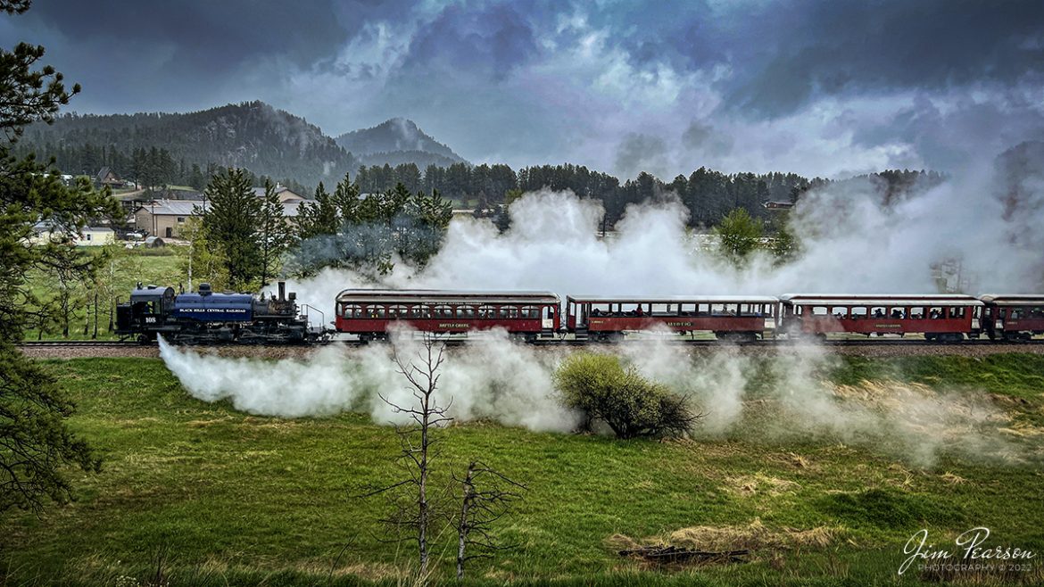 The 1880 Train, Black Hills Central Railroad locomotive crew on 108 performs a blow down on the engine as they arrive back at Hill City, SD on May 30th, 2022, under stormy skies. 

A Blowdown, where the left and right blow down valves, located at the lowest portion of the firebox sides (mud ring), are opened to blow out mineral sediments in the boiler water. Addition of various chemicals in the tender water is designed to keep the sediments (mud, etc.) from sticking to the internal steel components of the firebox/boiler. On a regular basis, those "settled" sediments need to blown out at safe locations on the railroad. Thus, the locomotives are being "blown down".

According to their website: Locomotive #108 joined its nearly identical twin, #110, at the beginning of the 2020 season following a four-year restoration. It is a 2-6-6-2T articulated tank engine that was built by the Baldwin Locomotives Works in 1926 for the Potlatch Lumber Company. It later made its way to Weyerhaeuser Timber Company and eventually to the Northwest Railway Museum in Snoqualmie, Washington.

The acquisition and subsequent restoration of locomotive #108 completed a more than 20-year goal of increasing passenger capacity which began with the restoration of #110 and the restoration of multiple passenger cars. Both large Mallet locomotives (pronounced Malley) can pull a full train of seven authentically restored passenger cars, up from the four cars utilized prior to their addition to the roster.

Tech Info: iPhone 13 Pro Max, 5.7mm, f/1.5, 1/1147, ISO 50.

#trainphotography #railroadphotography #trains #railways #jimpearsonphotography #trainphotographer #railroadphotographer #blackhillscentralrailroad #STEAM #steamtrains