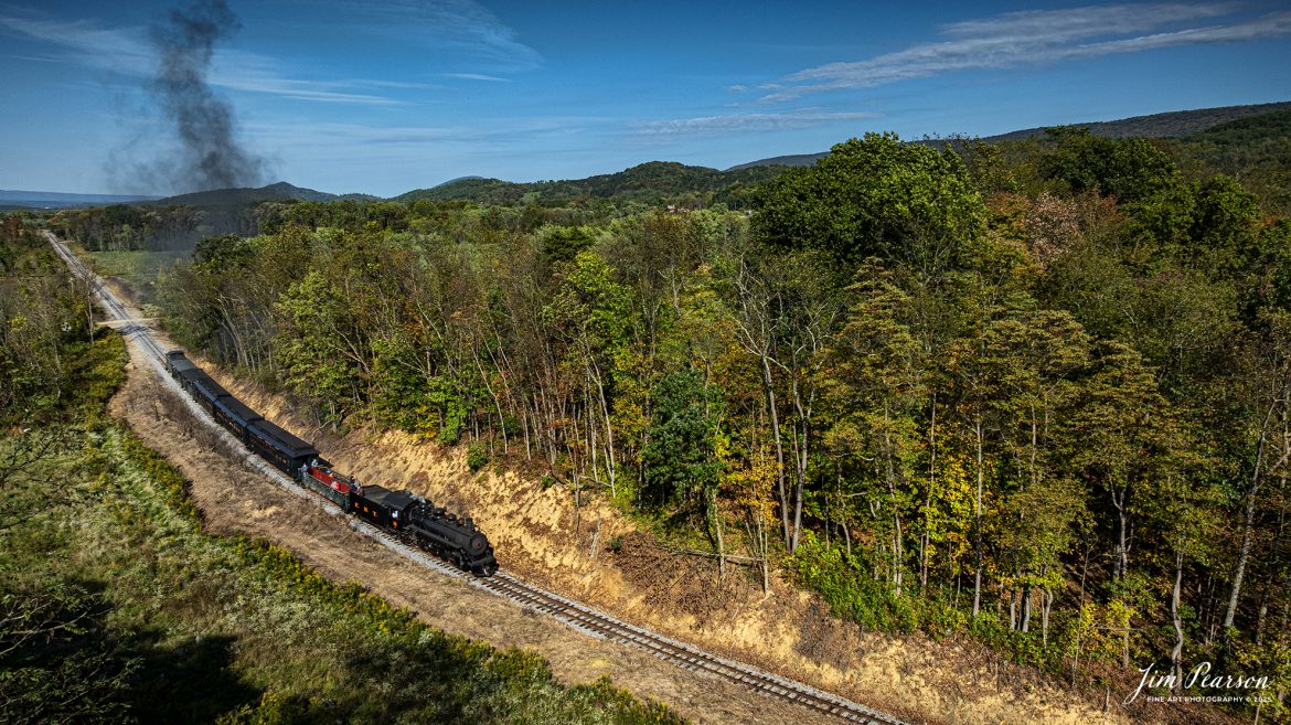 East Broad Top (EBT) steam locomotive #16 pulls a mixed freight through the countryside as they head to Rockhill Furnace, Pennsylvania on October 5th, 2024, during the museum’s Friends of the East Broad top event.

This is from a week-long trip I took with Bryan Burton (Photography) where we traveled 2,800 miles and covered steam operations at Reading and Blue Northern Railway (2102), East Broad Top Railroad, Strasburg Railroad and then a two-day photo charter by Dak Dillion Photography at the Valley Railroad in Essex, CT. It was a long, but fun and exciting trip for sure! You’ll see a lot of steam action over the coming weeks!

According to the East Broad Top Website: Locomotive #16 was built in 1916 by the Baldwin Locomotive Works.

Entering the age of modern steam in 1916, the EBT received its first of three large Mikados. Unlike the previous three smaller locomotives, #16 came with superheaters, piston valves, and Southern valve gear. One story mentions #16 pulled 60 empty hoppers from Mt. Union to Rockhill in one train, literally clearing out the yard. #16 underwent an overhaul in 1955 and made only a handful of trips in early 1956 before the railroad shut down an overhaul when the EBT shut down. On February 1, 2023, the locomotive returned to service.

Tech Info: DJI Mavic 3 Classic Drone, RAW, 24mm, f/2.8, 1/2000, ISO 100.

#railroad #railroads #train, #trains #railway #railway #steamtrains #railtransport #railroadengines #picturesoftrains #picturesofrailways #besttrainphotograph #bestphoto #photographyoftrains #bestsoldpicture #JimPearsonPhotography #trainsfromtheair #trainsfromadrone #EastBroadTop