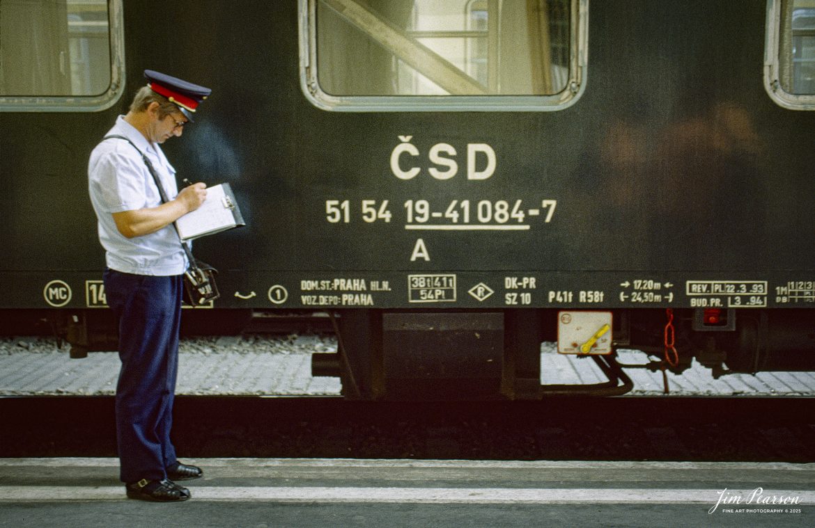 Film Wednesday – 1993 – Today’s slide scans are from time that I spent at the Budapest-Nyugati Railway Station, in Budapest, Hungry. This shot is of a conductor filling out his paperwork, prior to his train departing.

According to Wikipedia, Budapest Nyugati station (Hungarian: Nyugati pályaudvar, pronounced [ˈɲuɡɒti ˈpaːjɒudvɒr]; lit. 'western railway station'), generally referred to simply as Nyugati, is one of the three main railway terminals in Budapest, Hungary. The station is on the Pest side of Budapest, accessible by the 4 and 6 tramline and the M3 metro line.

The station was designed by Auguste de Serres and was built by the Eiffel Company. It was opened on 28 October 1877. It replaced another station, which was the terminus of Hungary's first railway line, the Pest–Vác line (constructed in 1846). This building was demolished to construct the Grand Boulevard.

The station got its name from the adjacent Western Square ('Nyugati tér'), a major intersection where Teréz körút (Theresia Boulevard), Szent István körút (Saint Stephen Boulevard), Váci út (Váci Avenue), and Bajcsy-Zsilinszky út (Bajcsy-Zsilinszky Avenue) converge. The square also serves as a transport hub with several bus routes, tram routes 4 and 6, and a station on M3 of the Budapest Metro.

Beside the terminal and partially above its open area there is the WestEnd City Center shopping mall. Inside the station is a McDonald's restaurant which has been described as the "most elegant" McDonald's in the world.

The music video for Gwen Stefani's 2008 single Early Winter was partly shot at Nyugati. Starting in May 2016 the key scenes of the movie Terminal were shot over 27 nights.

Tech Info: Camera, Nikon F3, Ektachrome Slide Film, no other data recorded, Scanned with an PlusTek 82001i Film Scanner.

#slidescan #filmphotography #trains #railroads #jimpearsonphotography #FilmPhotography