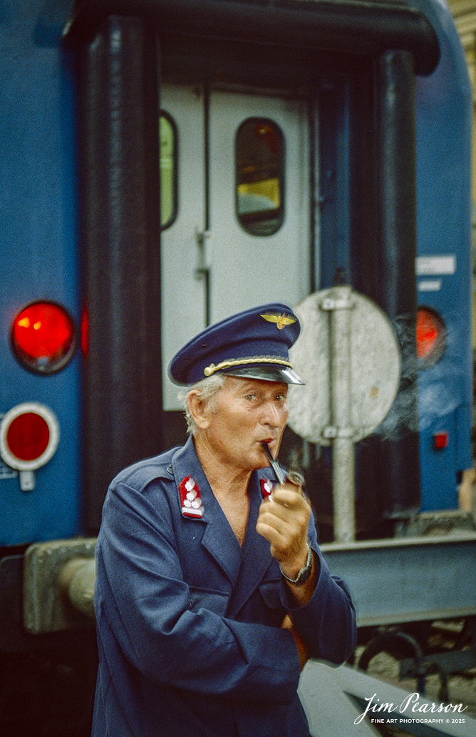 Film Wednesday – 1993 – Today’s slide scans are from time that I spent at the Budapest-Nyugati Railway Station, in Budapest, Hungry. This shot is a portrait of a worker that posed for me with his pipe! 

According to Wikipedia, Budapest Nyugati station (Hungarian: Nyugati pályaudvar, pronounced [ˈɲuɡɒti ˈpaːjɒudvɒr]; lit. 'western railway station'), generally referred to simply as Nyugati, is one of the three main railway terminals in Budapest, Hungary. The station is on the Pest side of Budapest, accessible by the 4 and 6 tramline and the M3 metro line.

The station was designed by Auguste de Serres and was built by the Eiffel Company. It was opened on 28 October 1877. It replaced another station, which was the terminus of Hungary's first railway line, the Pest–Vác line (constructed in 1846). This building was demolished to construct the Grand Boulevard.

The station got its name from the adjacent Western Square ('Nyugati tér'), a major intersection where Teréz körút (Theresia Boulevard), Szent István körút (Saint Stephen Boulevard), Váci út (Váci Avenue), and Bajcsy-Zsilinszky út (Bajcsy-Zsilinszky Avenue) converge. The square also serves as a transport hub with several bus routes, tram routes 4 and 6, and a station on M3 of the Budapest Metro.

Beside the terminal and partially above its open area there is the WestEnd City Center shopping mall. Inside the station is a McDonald's restaurant which has been described as the "most elegant" McDonald's in the world.

The music video for Gwen Stefani's 2008 single Early Winter was partly shot at Nyugati. Starting in May 2016 the key scenes of the movie Terminal were shot over 27 nights.

Tech Info: Camera, Nikon F3, Ektachrome Slide Film, no other data recorded, Scanned with an PlusTek 82001i Film Scanner.

#slidescan #filmphotography #trains #railroads #jimpearsonphotography #FilmPhotography